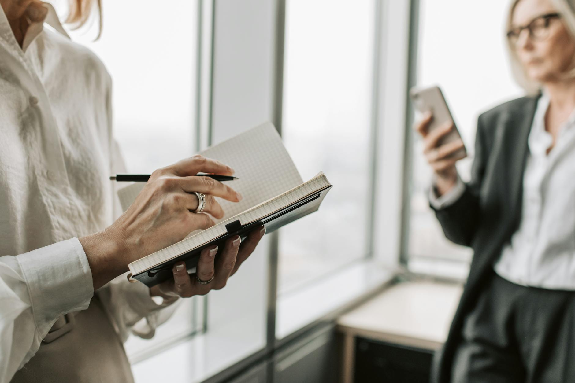 Candidate writing interview questions in a notebook before a meeting